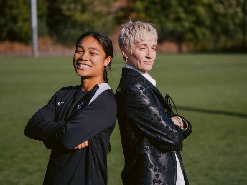 Megan Rapinoe and a UP athlete stand on the soccer pitch