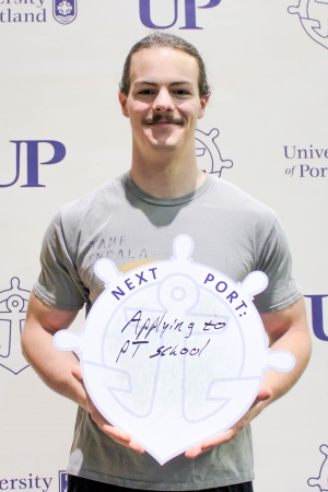 Joshua Pifer posing with Next Port sign.