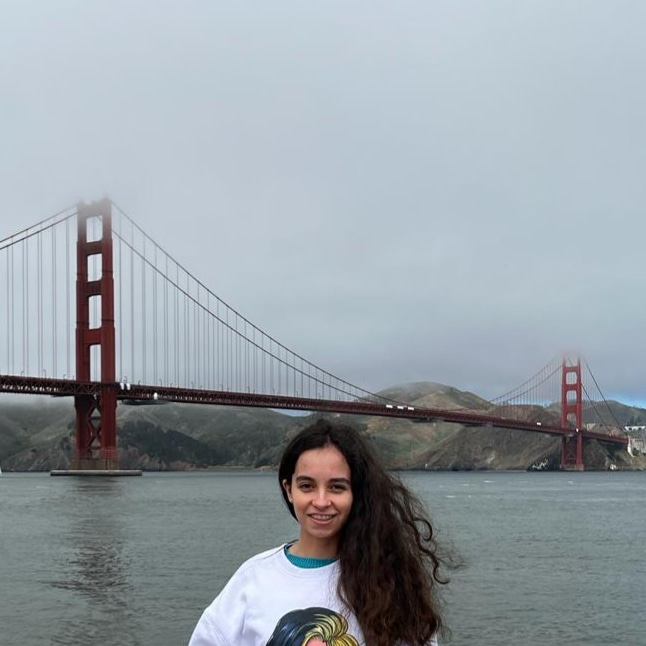 Maria stands in front of the Golden Gate Bridge