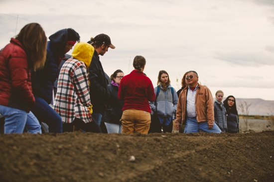 Students listen to a farmer while out on his land in Yakima, WA