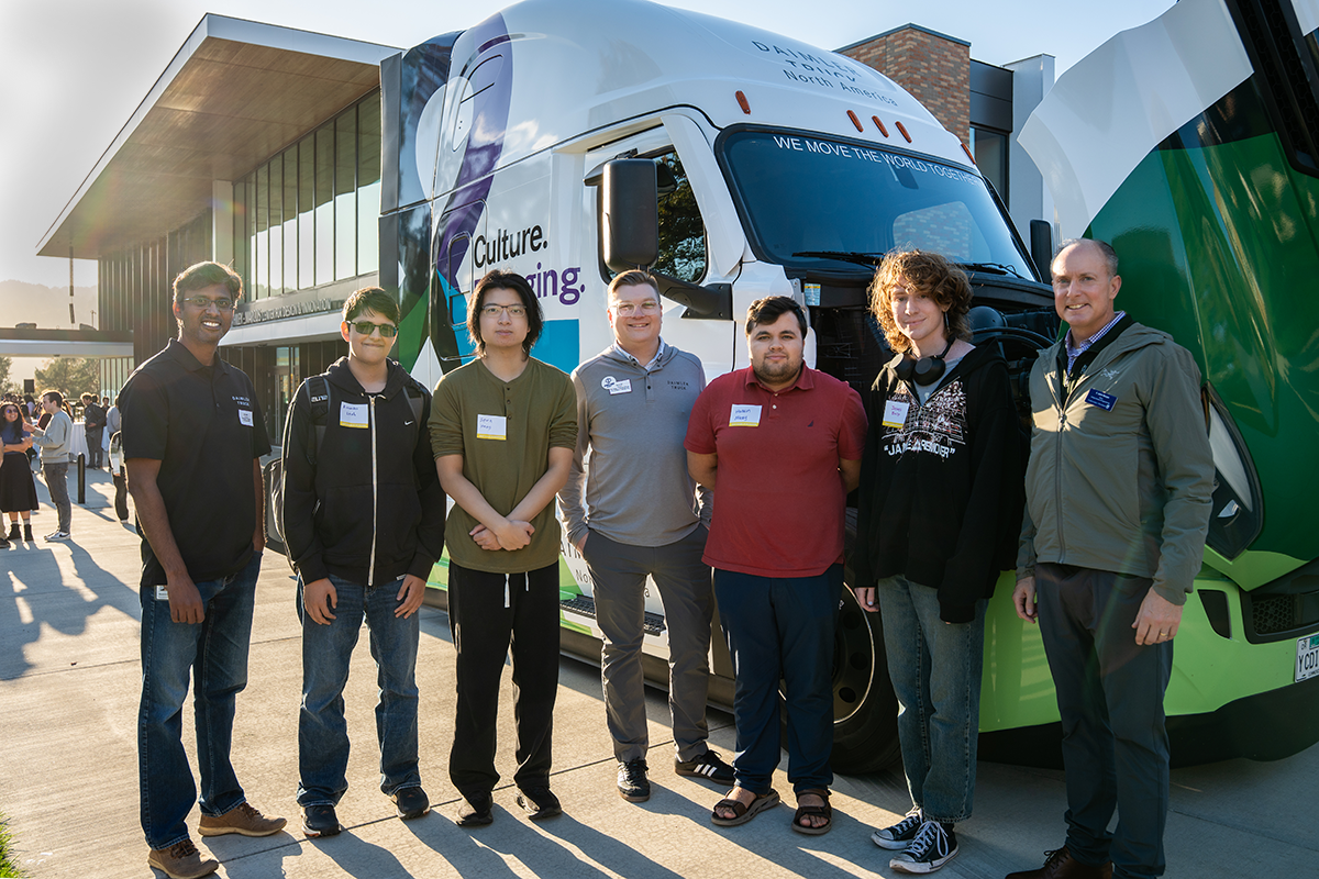 Students and Daimler Truck employees stand in front of a Daimler Semi cab outside of Shiley during the Daimler Day Event.