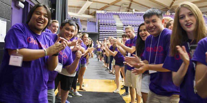 students looking at camera clapping