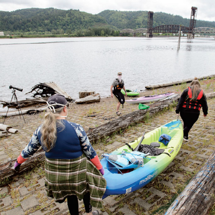 Two people carrying a kayak