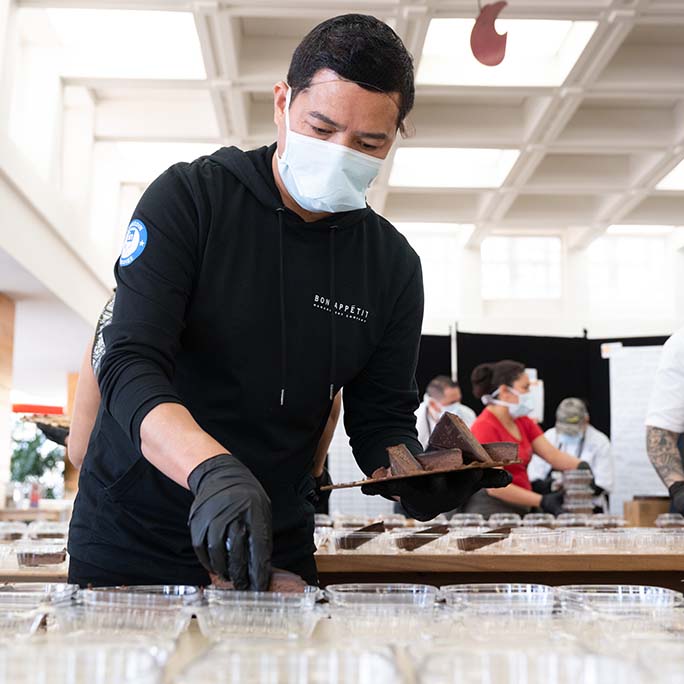 Worker putting cake in a container.