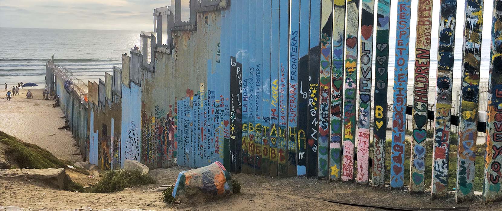 Border wall leading into the ocean.