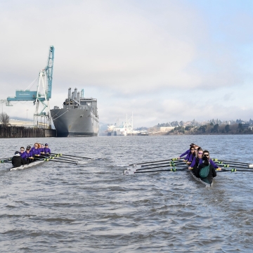 Two boats  glide down the river side by side