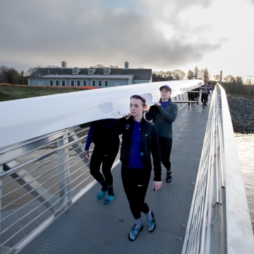 The rowing team carries a boat down the dock