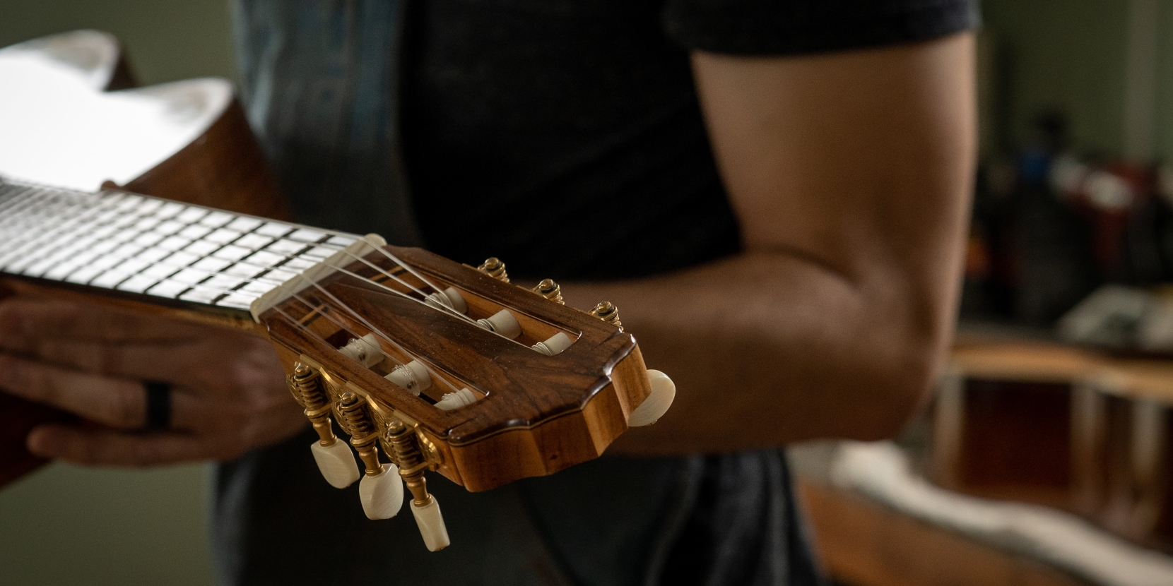 The luthier holds one of his guitars.