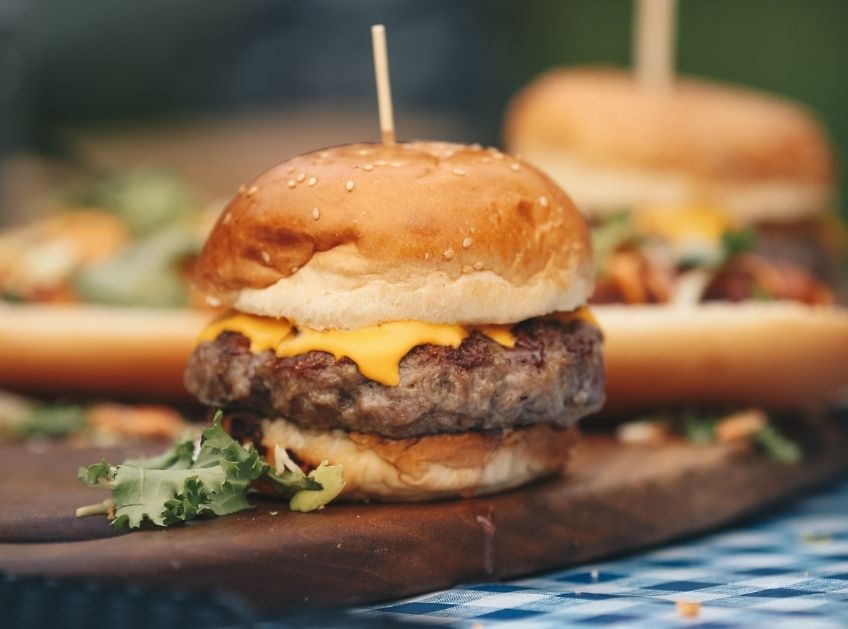 An image of a cheeseburger on a picnic table