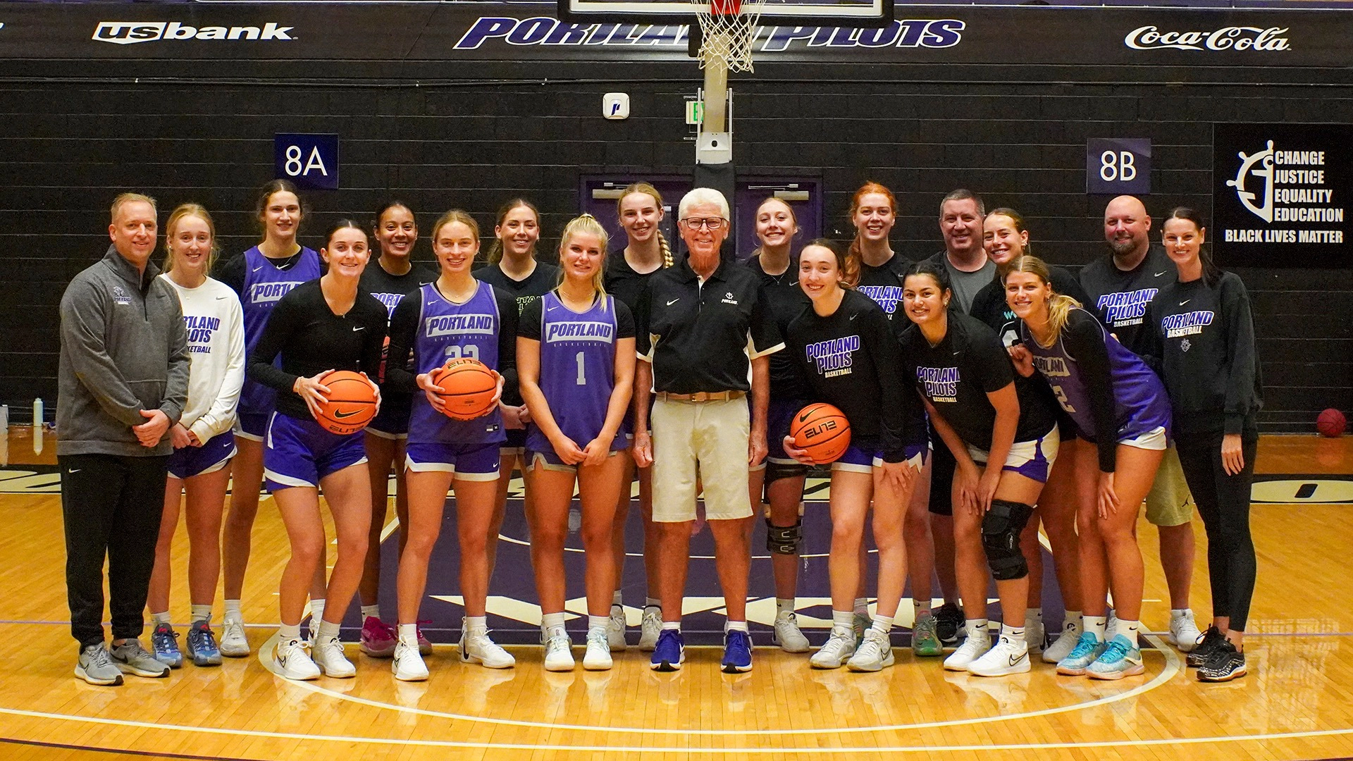 Doug Edwards (center) surrounded by the 2023 WCC Championship Basketball Team and Coaching Staff