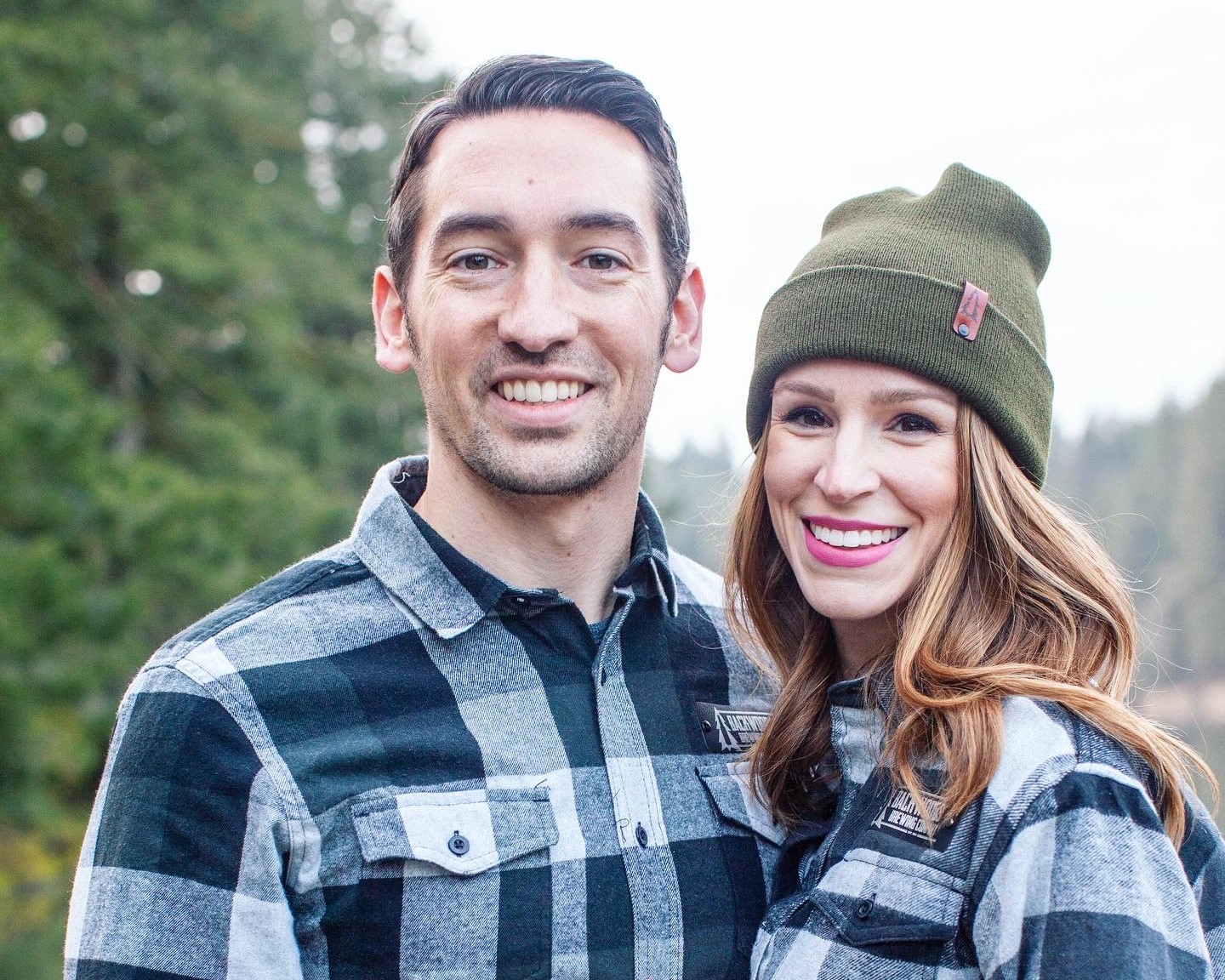 A portrait image of Steve and Michele Waters dressed in matching buffalo plaid flannel shirts.