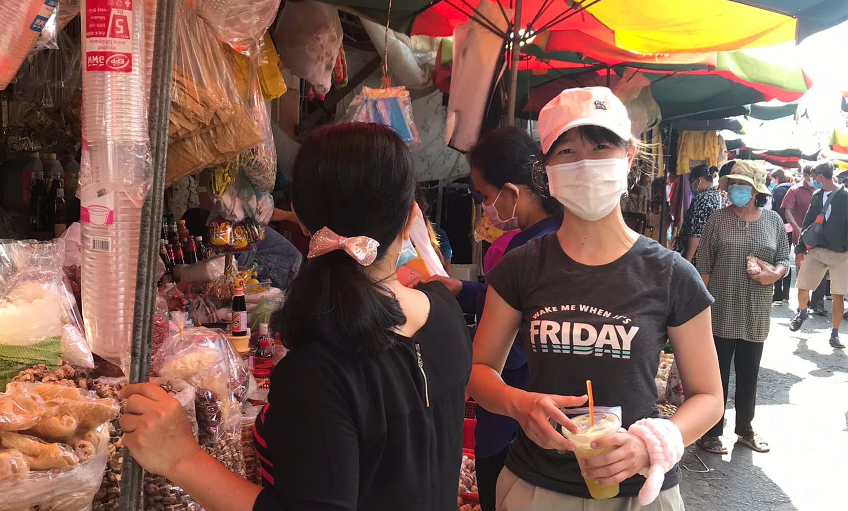 A UP student at a Cambodian market wearing a mask.