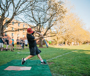 Softball player hitting a ball outdoors