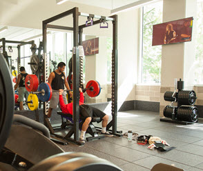 Student using bench press in weight room