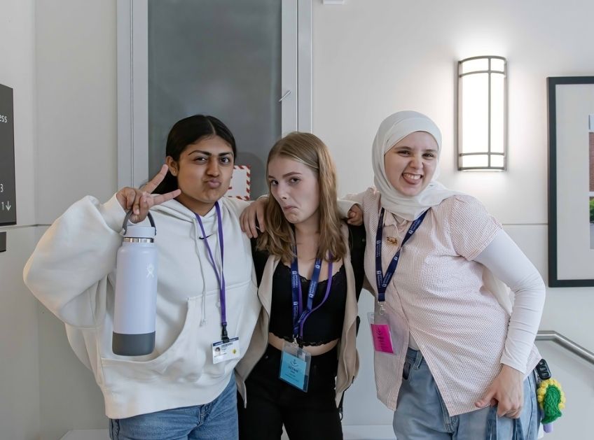 Three students pose together in the dormitory