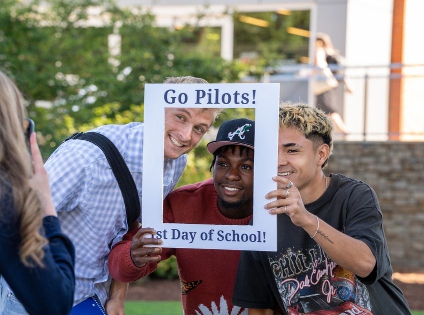 Three new students pose for a picture on campus