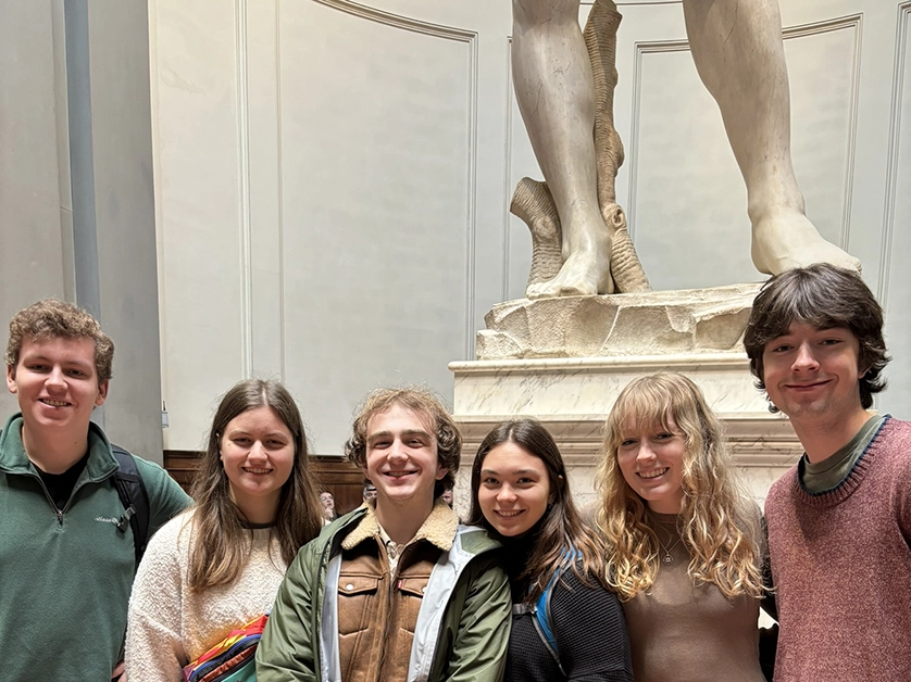 Students standing in front of a sculpture in a museum